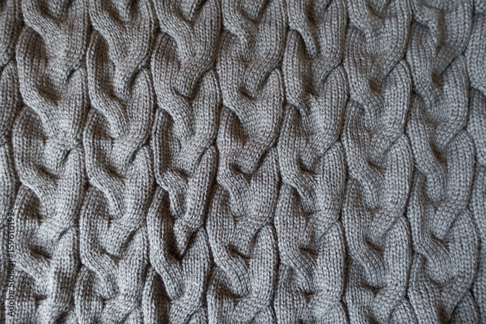 Plait pattern on grey knit fabric from above Plait pattern on grey knit fabric from above