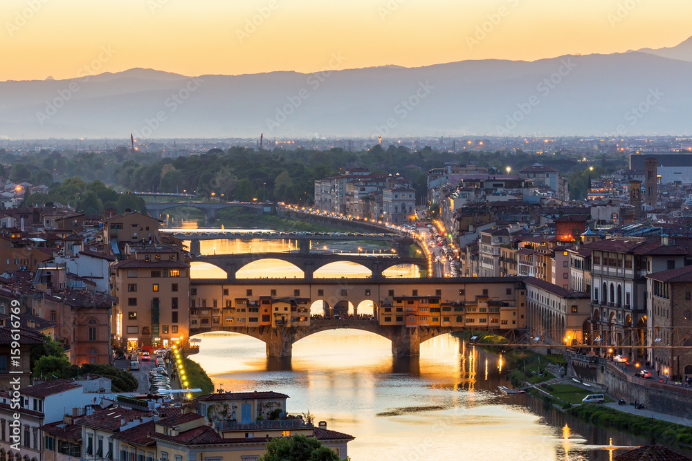 Obraz premium View of the Ponte Vecchio bridge over the Arno River in Florence with floodlight