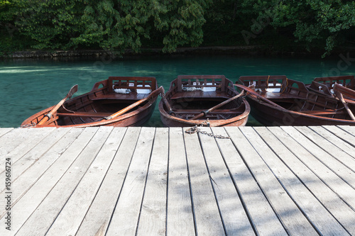 Small wooden boats near the pier on the lake