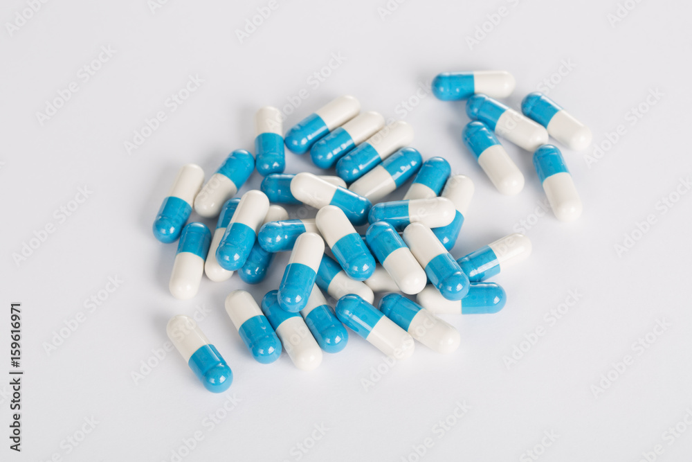 Closeup of medical blue pills on the white background.