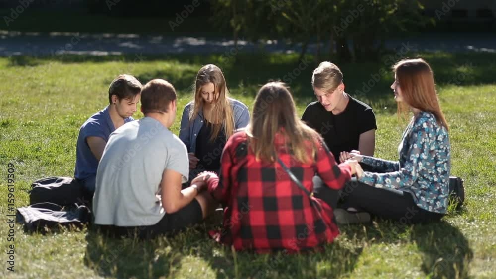 Young christians sitting in circle and praying Young christians sitting in circle and praying