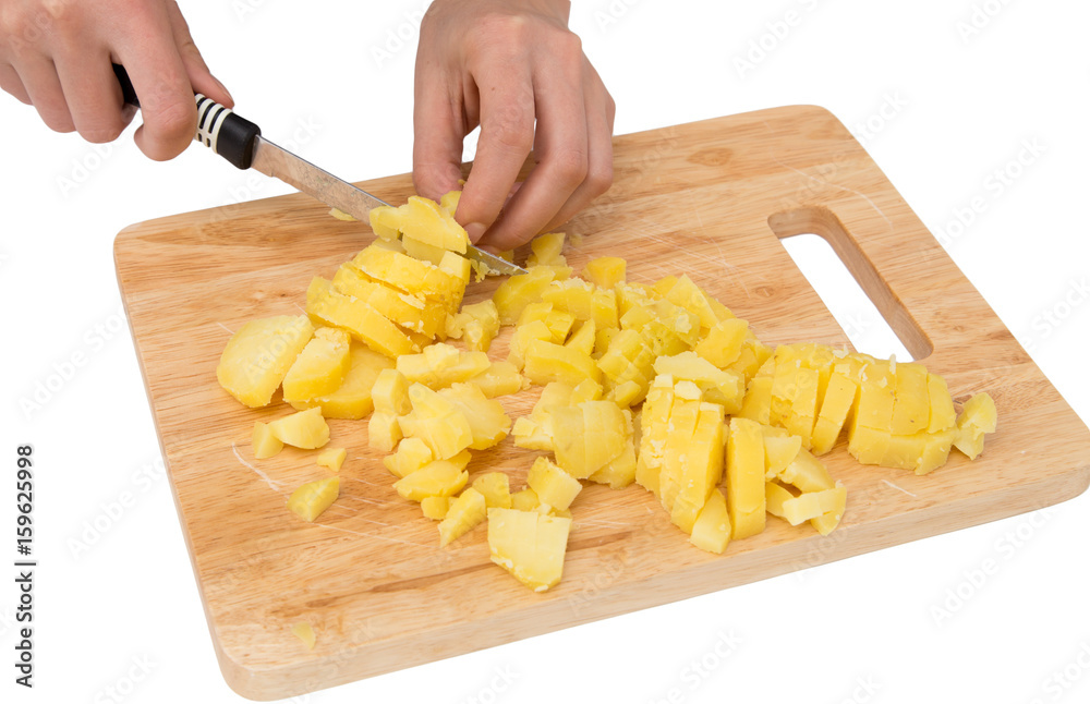Chef cuts boiled potatoes on board on a white background Chef cuts boiled potatoes on board on a white background