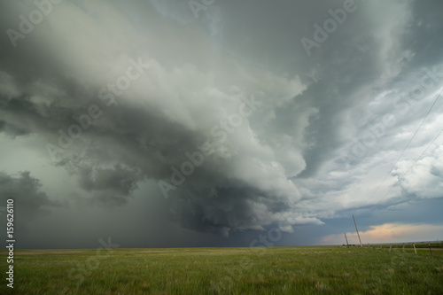 An arcing shelf cloud races forward as a severe thunderstorm approaches.
