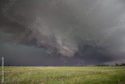 A rotating wall cloud hangs ominously under the base of a tornado-warned supercell thunderstorm. © Dan Ross