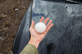 Storm chaser holds a baseball sized hailstone dropped by a supercell thunderstorm.