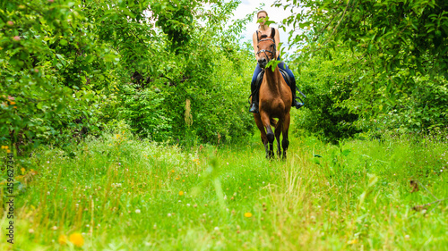Young woman ridding on a horse © Voyagerix
