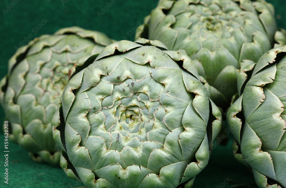 Obraz premium Green fresh globe artichokes on market display