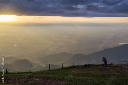 Tourists photograph the sunrise on the mountain