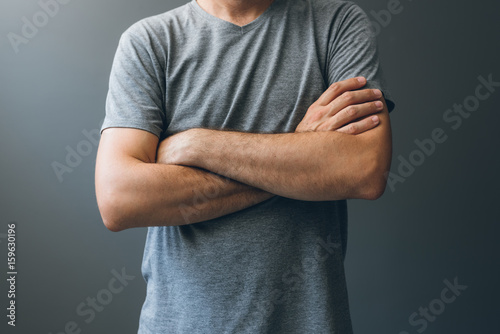 Casual adult man with arms crossed, body language photo