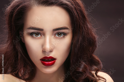 Beautiful woman with red lips on dark background