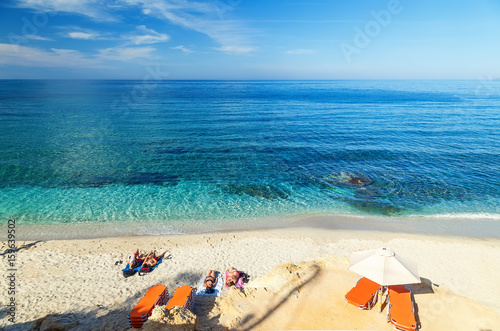 Fototapeta Naklejka Na Ścianę i Meble -  young boys and girls on beautiful beach with blue water and white sand, Crete, Greece