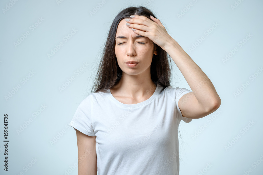 Young pretty brunette girl touching her head Young pretty brunette girl touching her head
