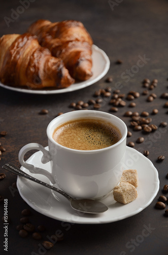 Fototapeta Naklejka Na Ścianę i Meble -  Cup of fresh coffee with croissants on dark background, selective focus