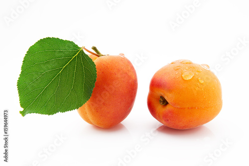 Ripe, juicy and appetizing apricot fruits with green leaves