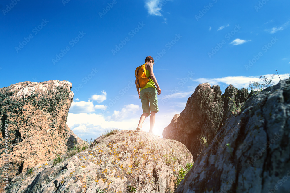 Girl with a backpack walks in picturesque places.