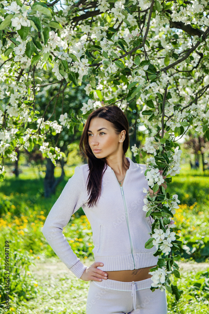 Beautiful brunette posing in blossoming apple-trees Beautiful brunette posing in blossoming apple-trees