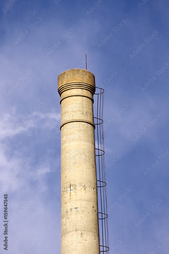 Isolated old aged weathered tall industrial factory chimney
