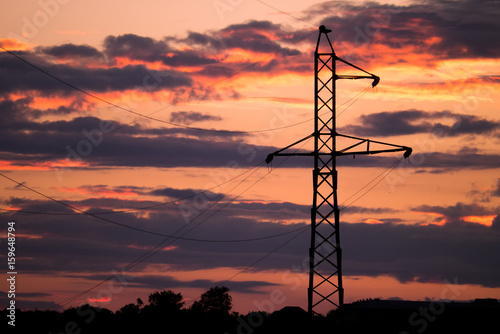 High voltage electricity pylon on the sunset. Silhouette of electrical tower.