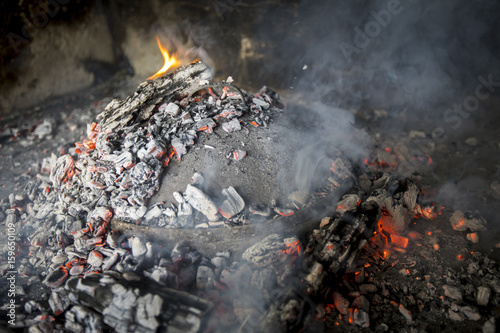 Oktopus und Kartoffel, Traditionelle Zubereitung in Stahlpfanne mit Deckel ( ispod pike ) bei offenem Feuer
