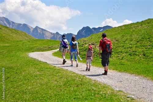 Wanderer wandern auf Wanderweg in den Schweizer Berge,. Im Hintergrund der Berg Hoh Brisen (Gipfel der Urner Alpen)