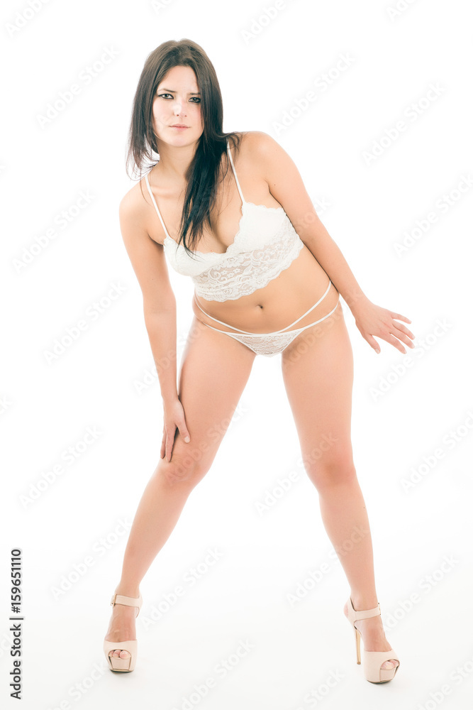 Young woman poses in white lingerie on white background Young woman poses in white lingerie on white background