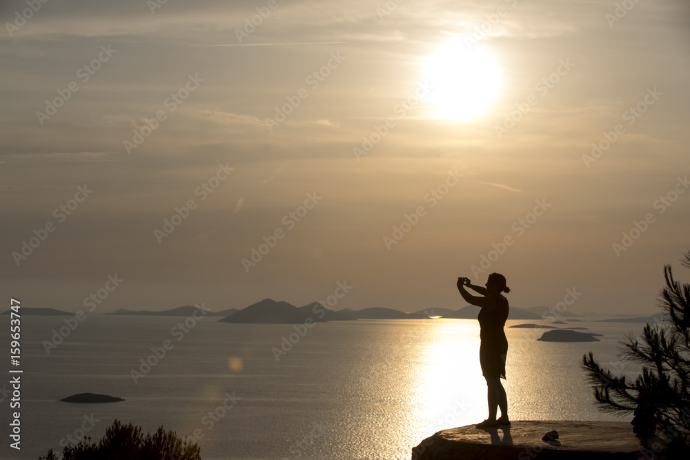 Sonnenuntergang auf den Kornaten, Frau genießt letzte Sonnenstrahlen auf der Insel Zirje, Kroatien