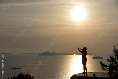 Obraz na płótnie Sonnenuntergang auf den Kornaten, Frau genießt letzte Sonnenstrahlen auf der Insel Zirje, Kroatien w salonie