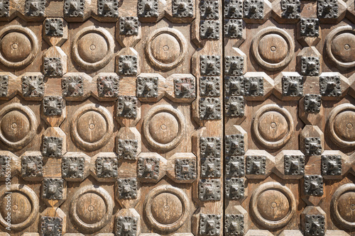 ancient brown wooden door with metallic ornaments