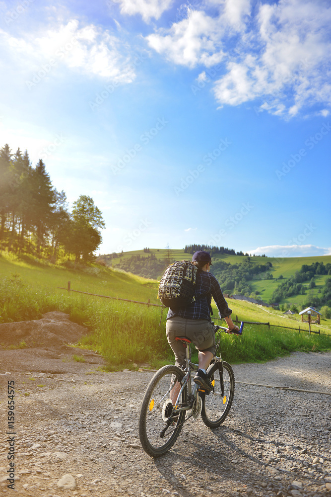 The girl is riding a bicsycle in the woods