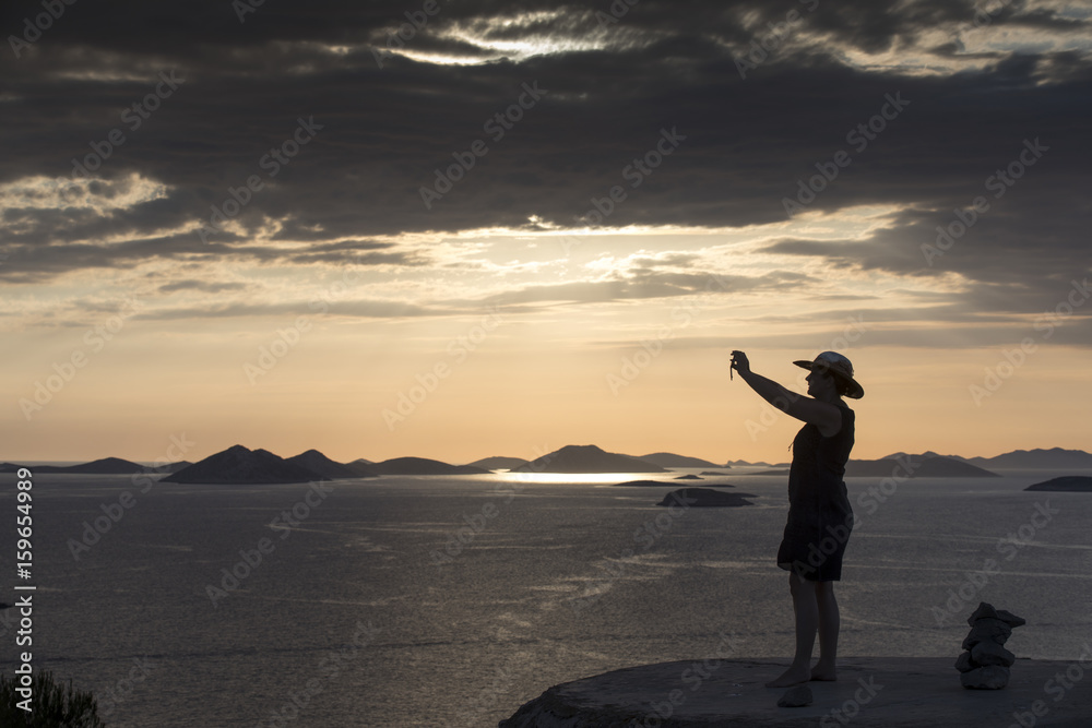 Sonnenuntergang auf den Kornaten, Frau genießt letzte Sonnenstrahlen auf der Insel Zirje, Kroatien