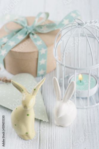 Mint green lit candle in white lantern with gift