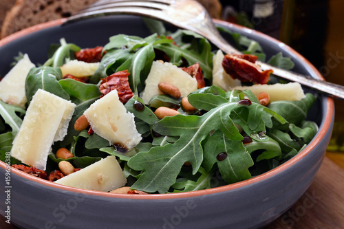 Rucolasalat mit Parmesan in Terracotta Schüssel, Nahaufnahme, Foodstyling photo
