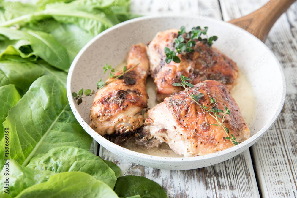 Fototapeta premium Fried golden chicken thighs with spices and herbs. Baked chicken legs