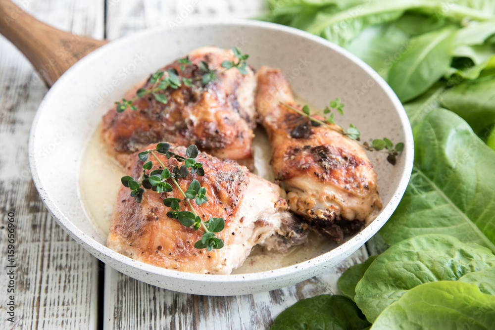 Fototapeta premium Fried golden chicken thighs with spices and herbs. Baked chicken legs