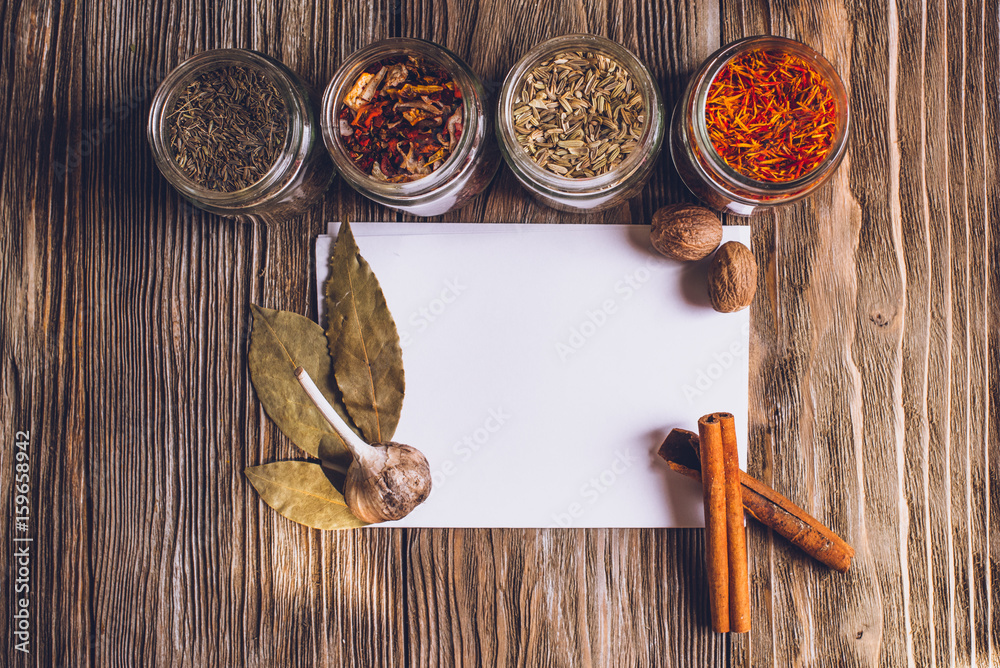 Various colorful kinds of spices on rustic wooden table, top view with copy space