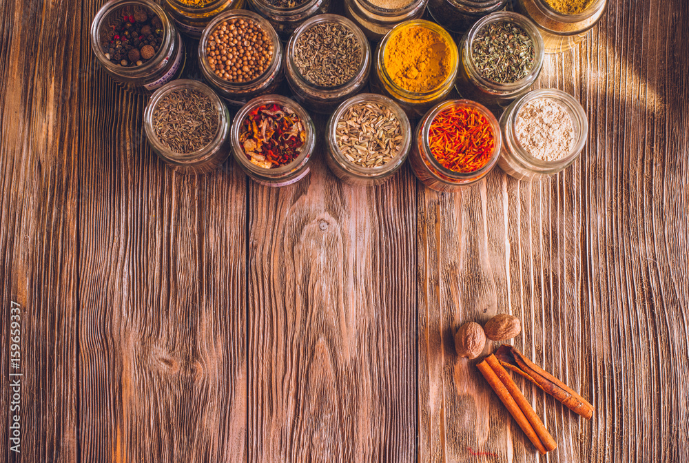 Various colorful kinds of spices on rustic wooden table, top view with copy space Various colorful kinds of spices on rustic wooden table, top view with copy space