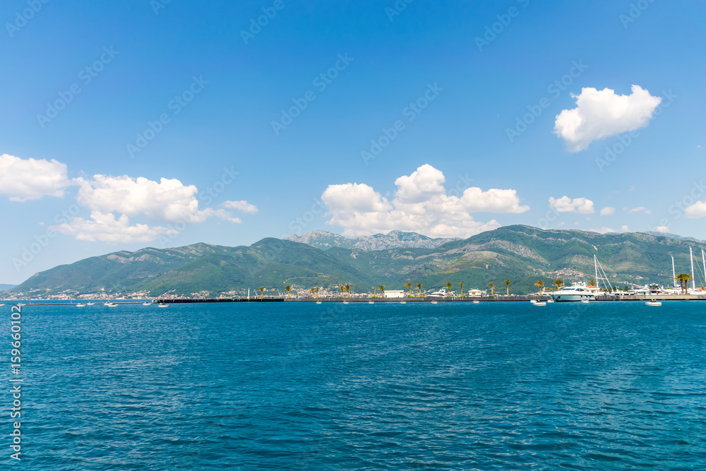 Yachts of various sizes and large vessels moored in the port of Tivat.