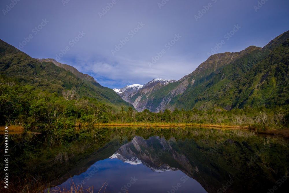 Fototapeta premium Small pond peters pond with reflection of mountain glacier Franz Josef Glacier in New Zealand