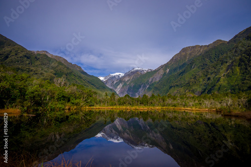 Fototapeta Naklejka Na Ścianę i Meble -  Small pond peters pond with reflection of mountain glacier Franz Josef Glacier in New Zealand