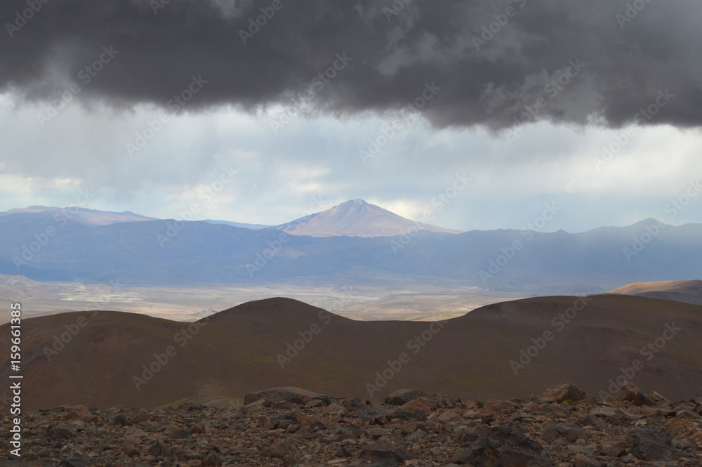 Awe-inspiring landscape of the puna salteña from the snowy of Acay, with a low ceiling of natural clouds