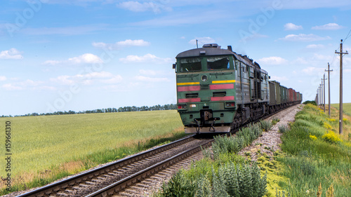 train goes on rails in summer field