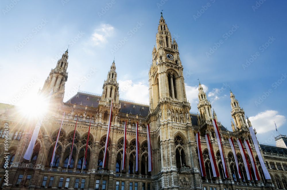 Obraz premium Wiener Rathaus (ratusz w Wiedniu, Austria) o zachodzie słońca, z austriackimi flagami na fasadzie