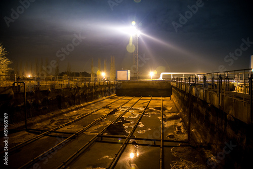 Modern wastewater treatment plant of chemical factory at night. Water purification tanks