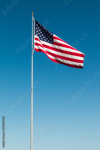 American Flag with the background of a blue sky.  