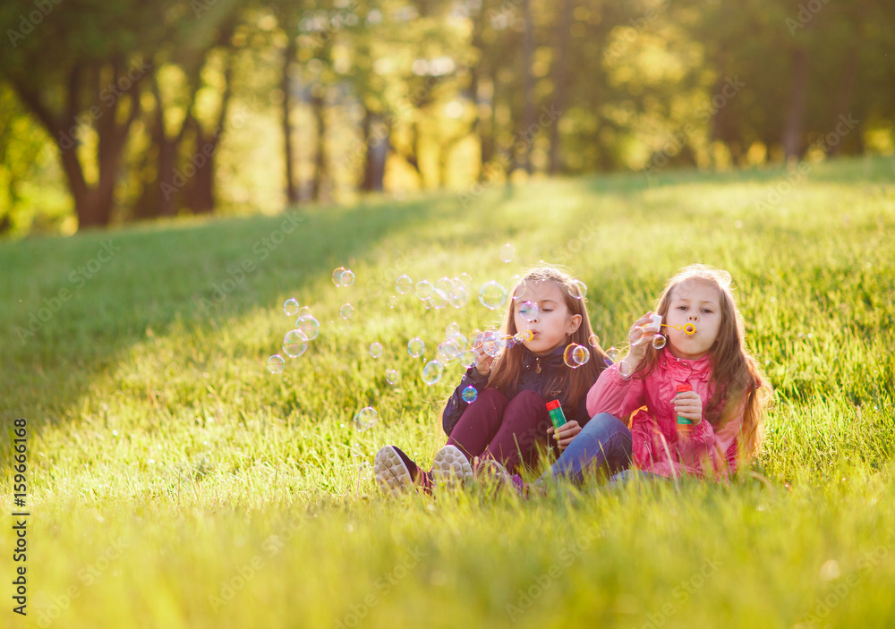 Fototapeta premium Girls play with soap bubbles.