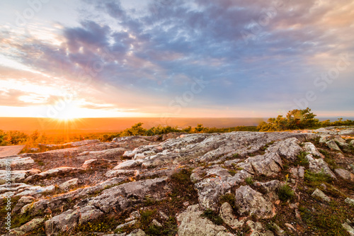 Sun sets over rocky granite outcroppings in early summer at top of New Jersey, High Point State Park
