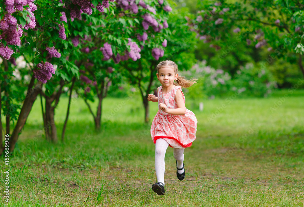 A little girl is running in the park. A little girl is running in the park.