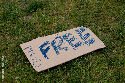 Free handwritten sign on cardboard against green grass photo