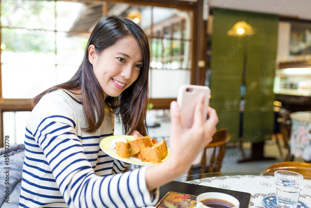 Woman taking selfie with her breakfast