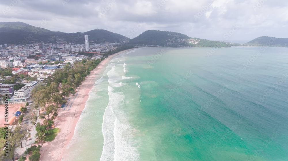 Aerial view of sandy beach with tourists swimming in beautiful clear sea water, Patong beach south of Thailand
